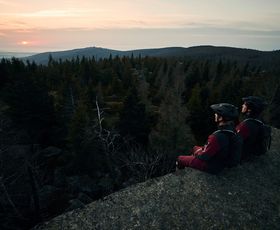 zwei mountainbiker sitzen auf einer felsklippe im harz