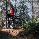 mountainbiker steht auf felsen